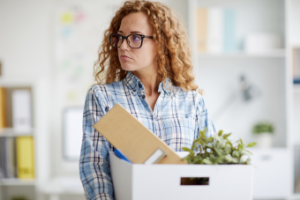 A woman holding a box with her belongings.
