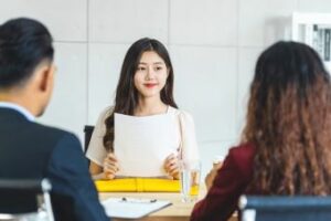 Two people seeking a job in a meeting with a hiring manager.