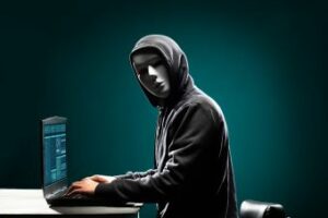 Anonymous figure typing on a laptop.