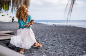A woman at the beach on her phone.