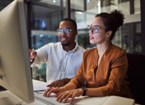 Manager training employee on computer