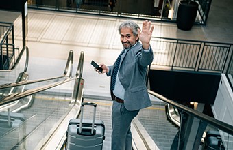 Business man waving goodbye with luggage