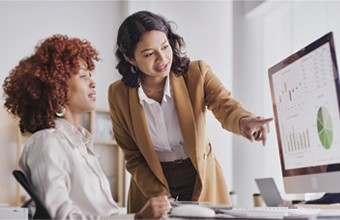 Employees reviewing data graphics on computer