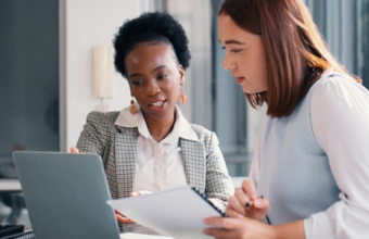 Two employees working on a payroll audit.