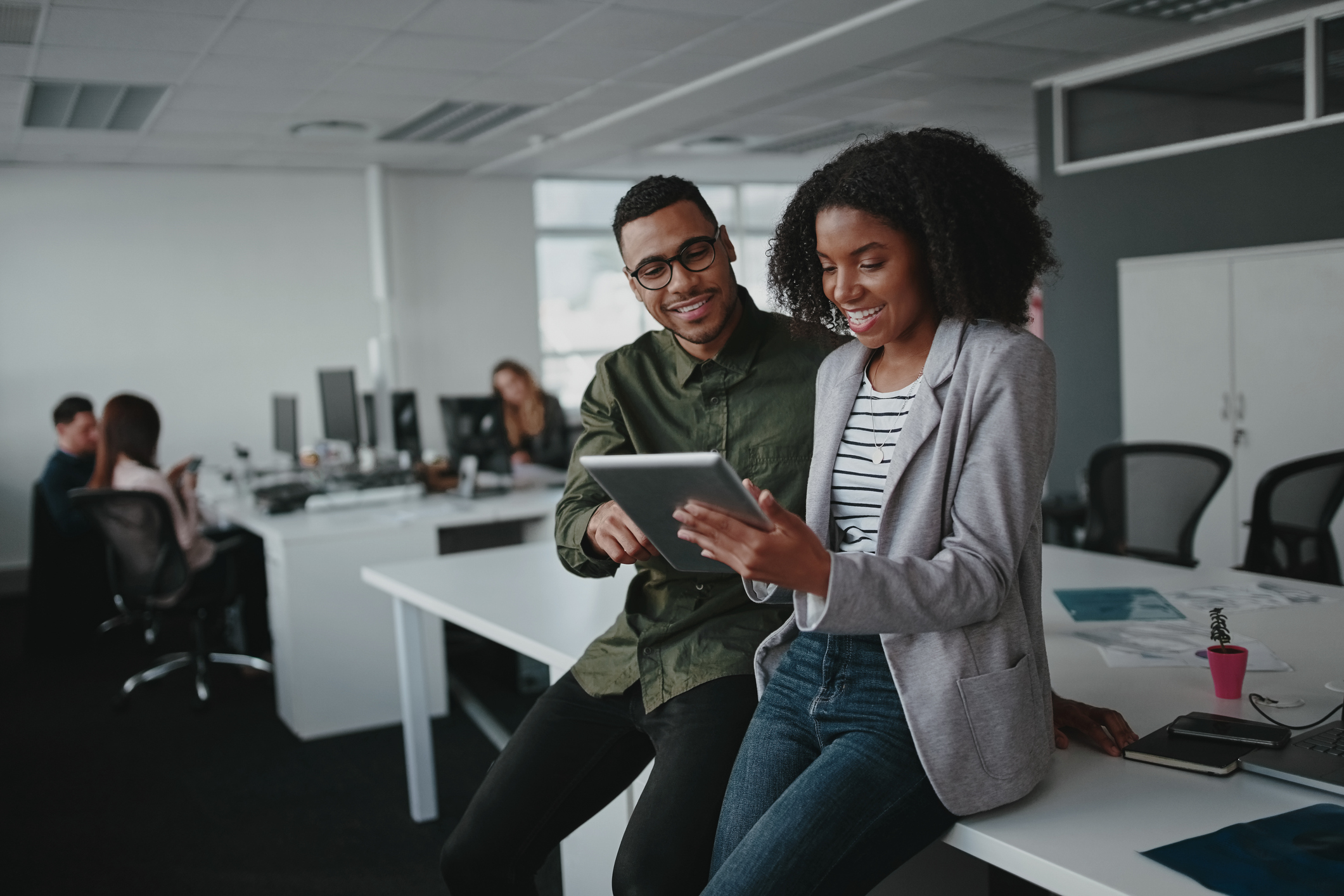 A man and woman looking at a tablet in the office