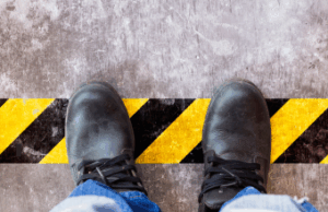 Employee standing on hazard tape on factory floor