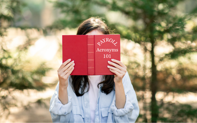 Woman reading Payroll Acronyms 101 book