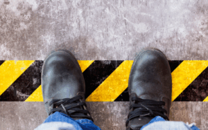 Employee standing on hazard tape on factory floor