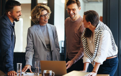 Four employees looking at benefits on a laptop.