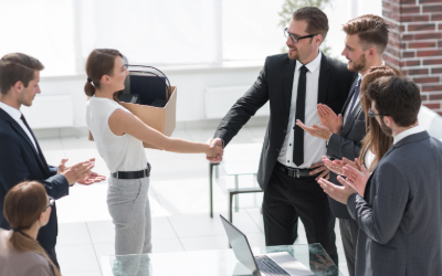Group at an offboarding meeting shaking the new former employee's hand