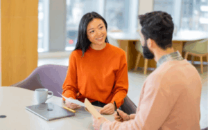 Two coworkers conversing at conference table