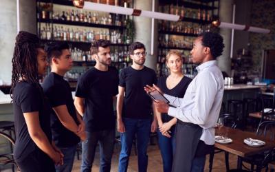 A restaurant's team lead giving his team instructions