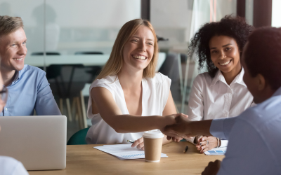 Man and woman shaking hands in a meeting.