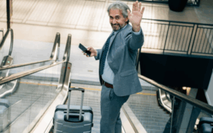 Business man waving goodbye with luggage