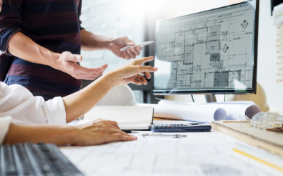 Two colleagues working on digital blueprints on their monitor