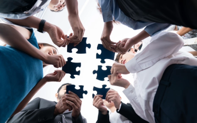 Team putting together a puzzle to symbolize merging.