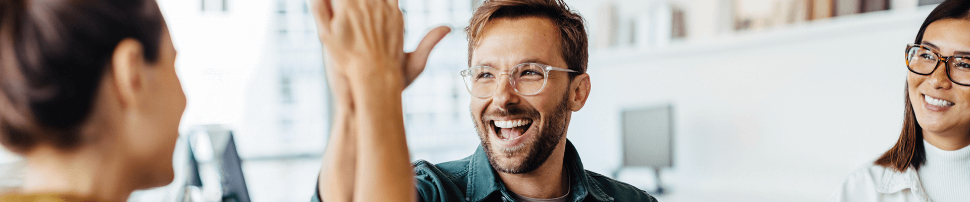 Co workers high-fiving in an office.