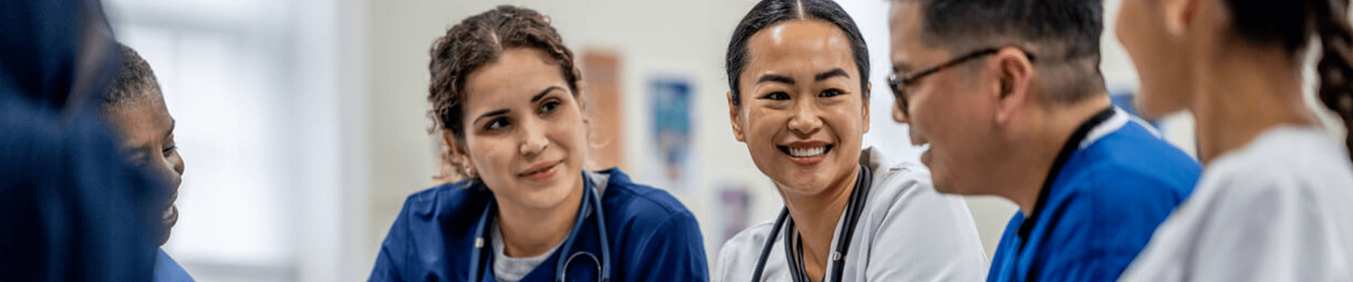 Multiple medical professionals talking in a meeting.