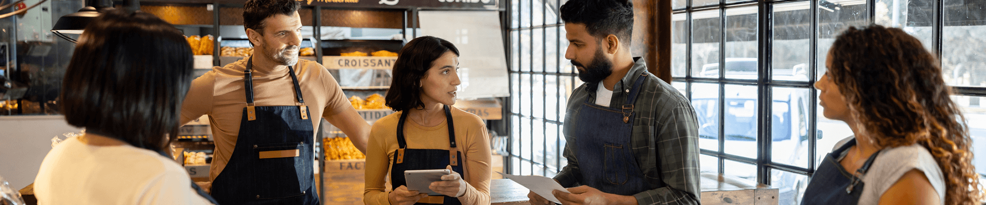 Multiple cafe workers in a group meeting.