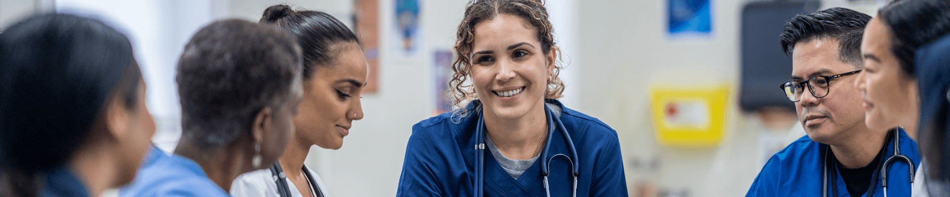 Multiple medical professionals talking to each other in a meeting.