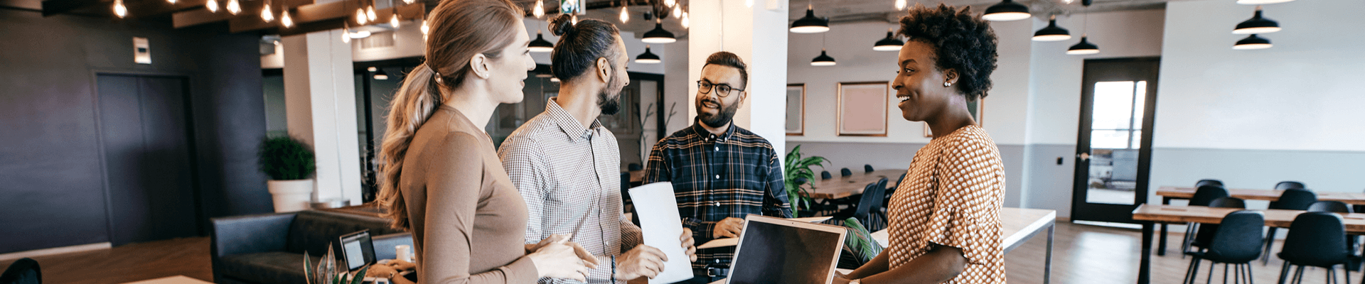 Four co-workers talking in an office.