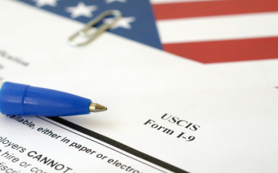 Zoom of the top part of the I-9 form with a U.S.A. flag in the background.