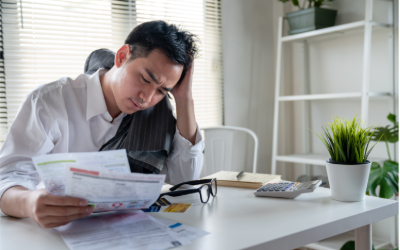 Man looking at papers showing a confused or frustrated face.