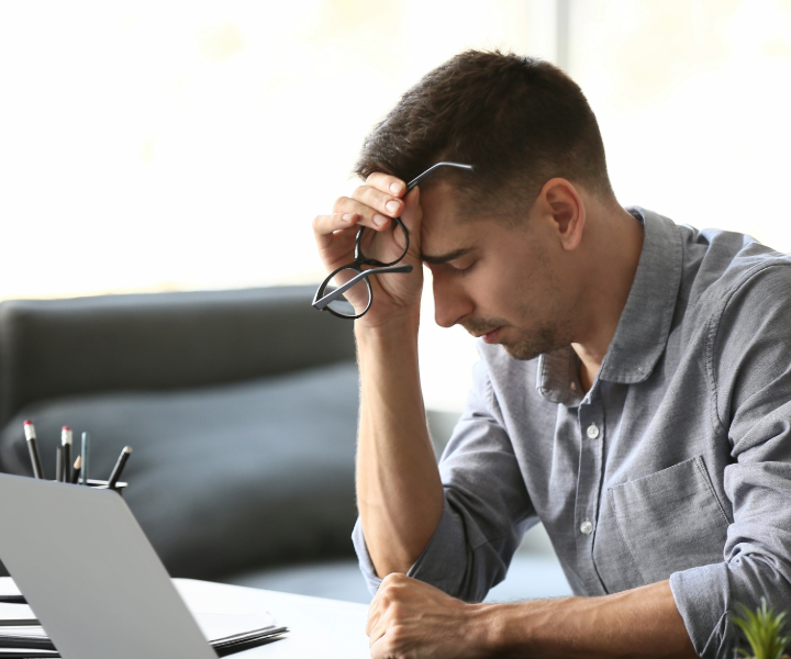 A tense man leaning his face on his hand showing concern or frustration