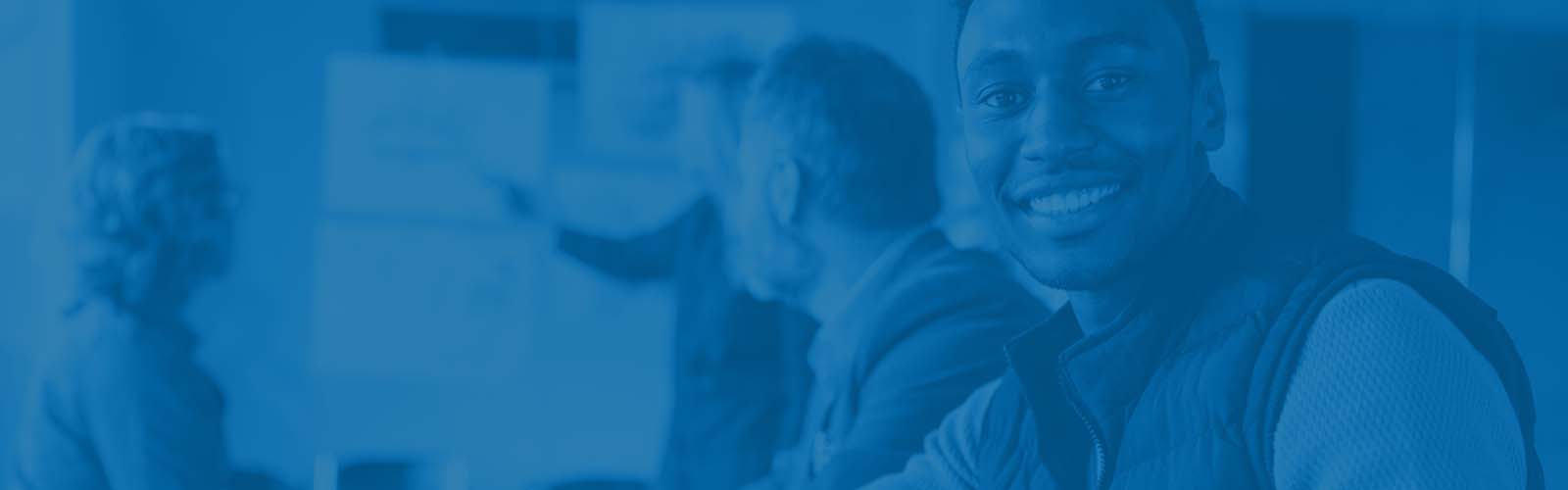 Man smiling looking the other way from a presentation happening in the back