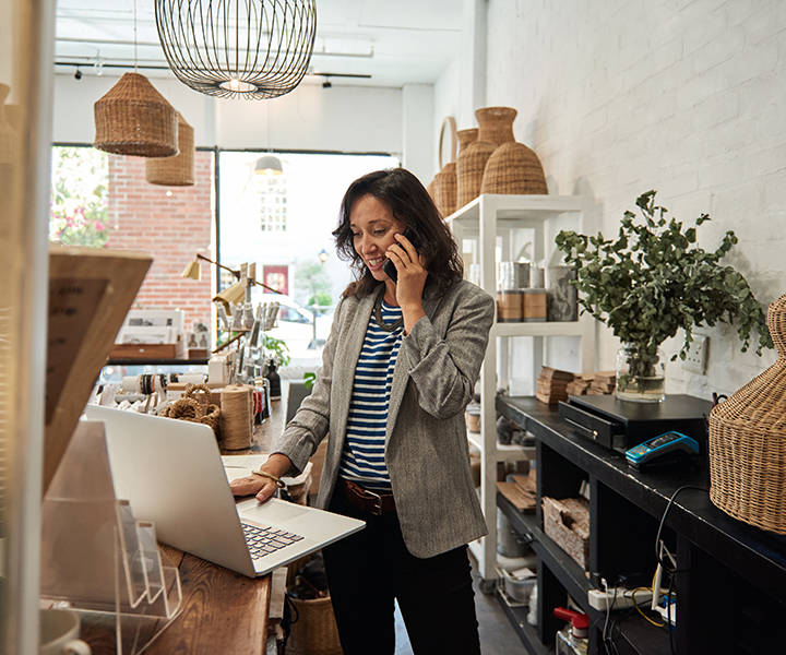 Smiling woman talking on a cellphone in her store